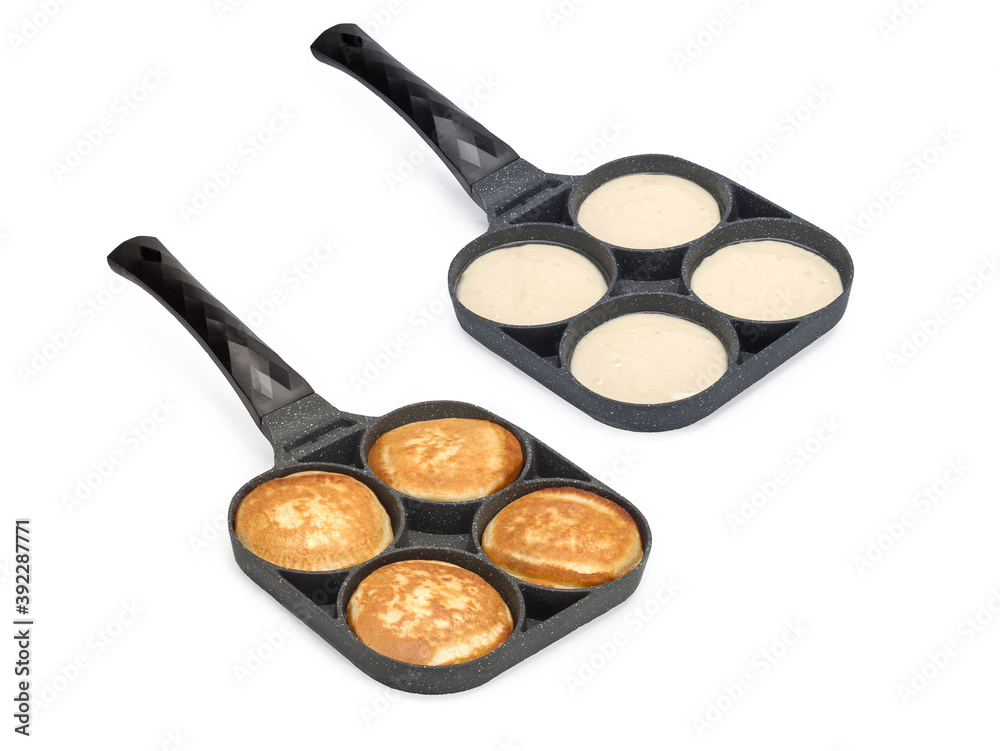 Two frying pans for pancakes top view. Cooking pancakes. Isolated on white Two frying pans for pancakes top view. Cooking pancakes. Isolated on white