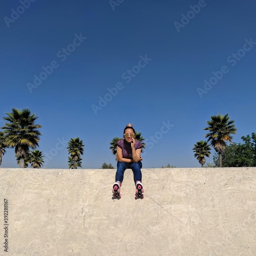Modelo mujer patinando sonriendo descansando en skatepark