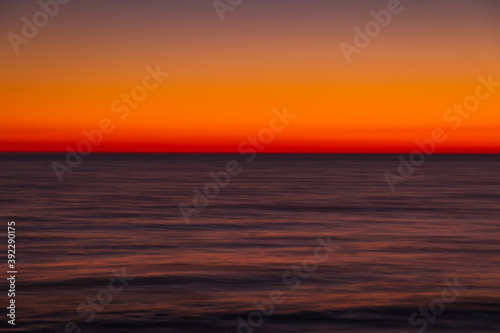 Ocean with waves at bright sunset or sunrise shooting with exposure