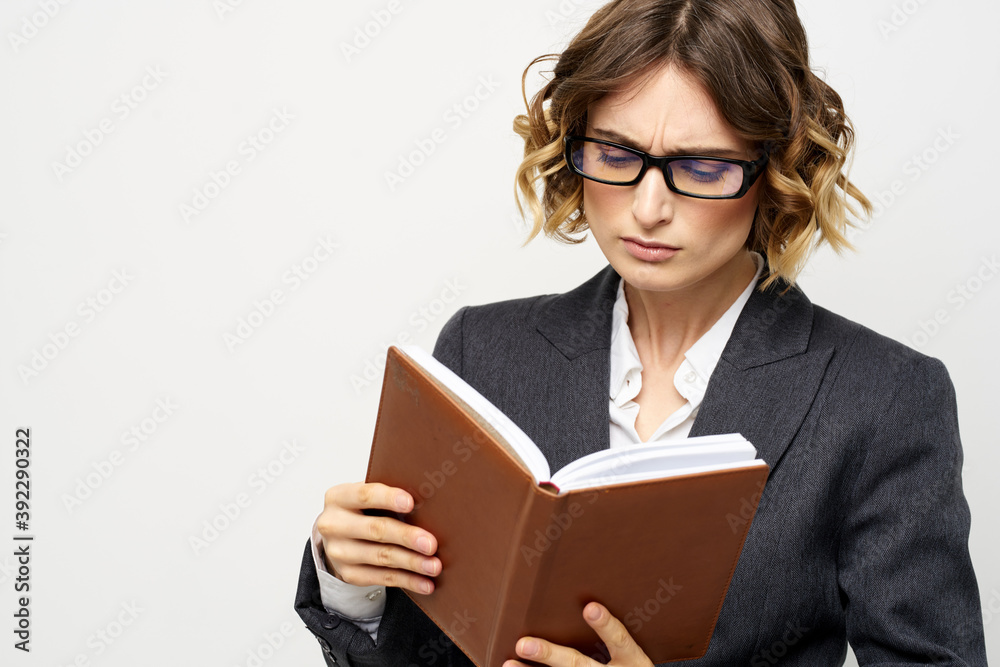 Business woman with notepad and glasses work light background cropped view of suit model. Business woman with notepad and glasses work light background cropped view of suit model.