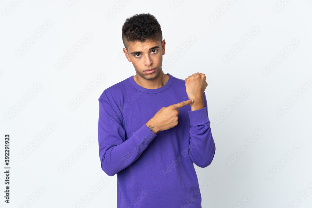 Young brazilian man isolated on white background making the gesture of being late Young brazilian man isolated on white background making the gesture of being late