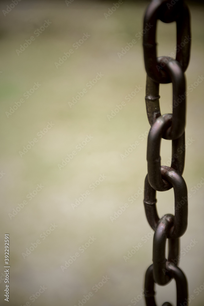 Long faded black rusty chain at public park Long faded black rusty chain at public park