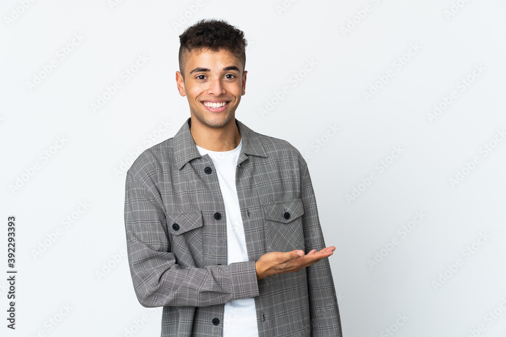 Young brazilian man isolated on white background presenting an idea while looking smiling towards Young brazilian man isolated on white background presenting an idea while looking smiling towards