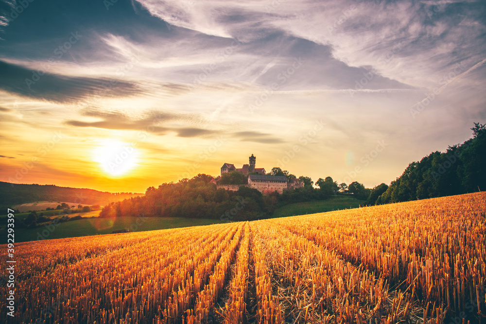 The Ronneburg in Germany in a great landscape photo. Beautiful fields with a castle and in the sunset

