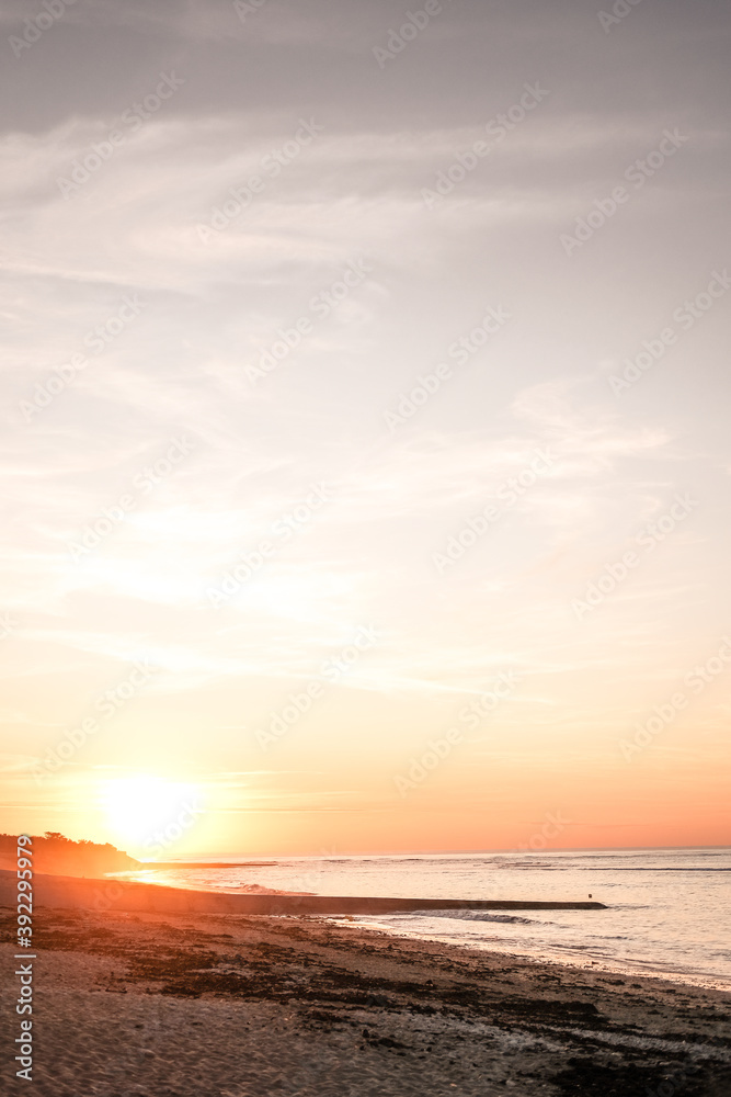 puesta de sol naranja sobre playa francesa, en las isla de re.