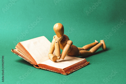 Obraz na płótnie Wooden man lie down and rest on an open book. Education concept. w salonie