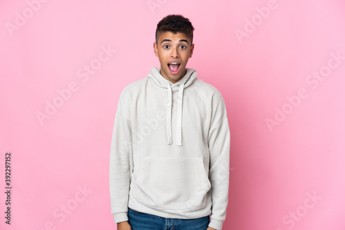 Young Brazilian man isolated on pink background with surprise facial expression