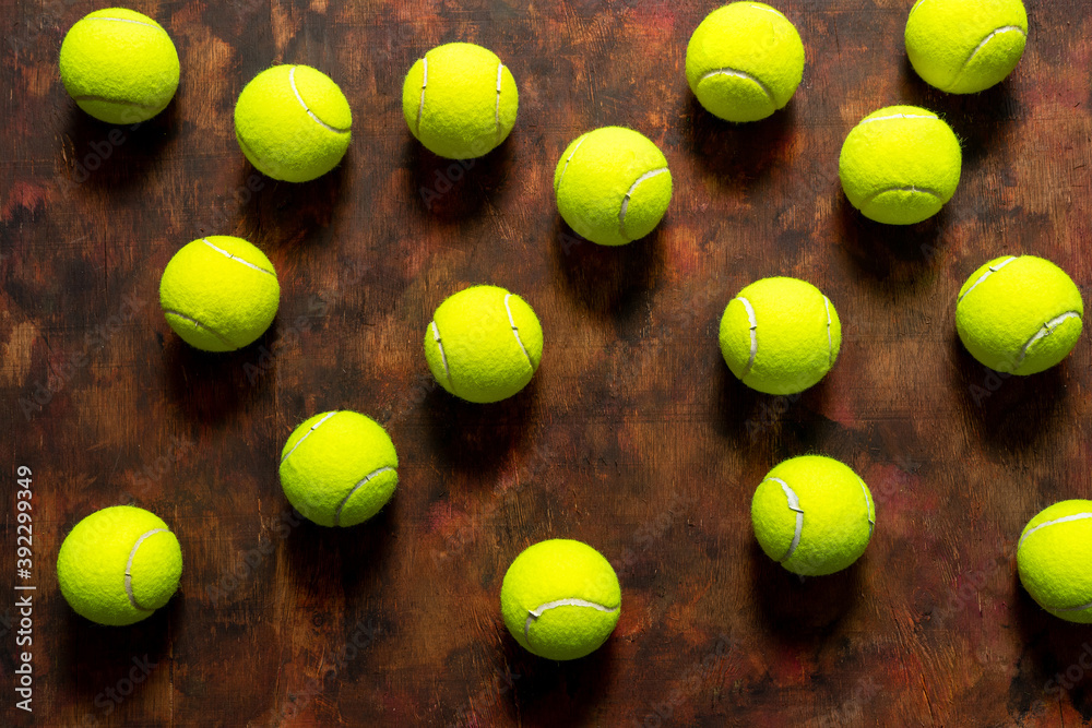 Tennis balls in composition on old wooden background in brown tones