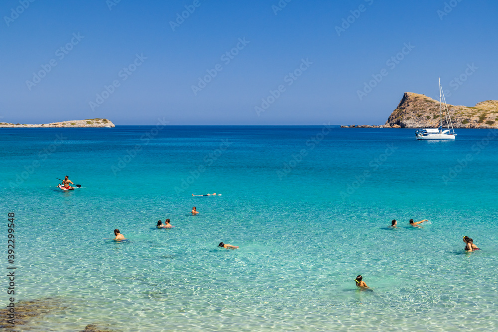 Swimmers, Snorkellers and sailboats on a clear ocean Swimmers, Snorkellers and sailboats on a clear ocean