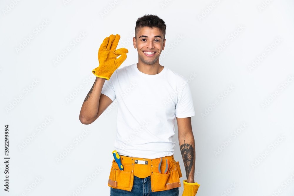 Young Brazilian electrician manipulated isolated on white background showing ok sign with fingers Young Brazilian electrician manipulated isolated on white background showing ok sign with fingers