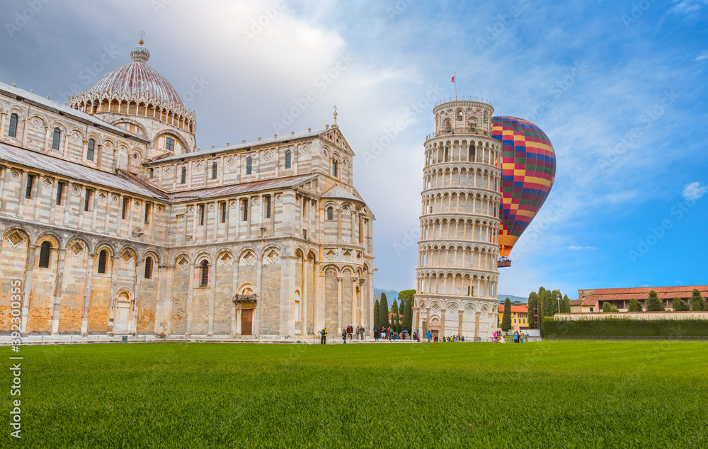 Hot air balloon flying over Pisa, Piazza dei miracoli, with the Basilica and the leaning tower - Italy