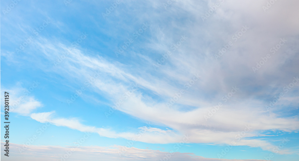 Blue sky and white clouds background - Pillowy clouds cover a blue sky in the background Blue sky and white clouds background - Pillowy clouds cover a blue sky in the background