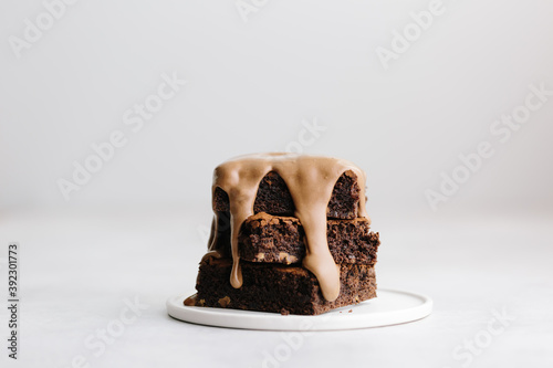 Chocolate ganache sauce poured over brownie stack photo
