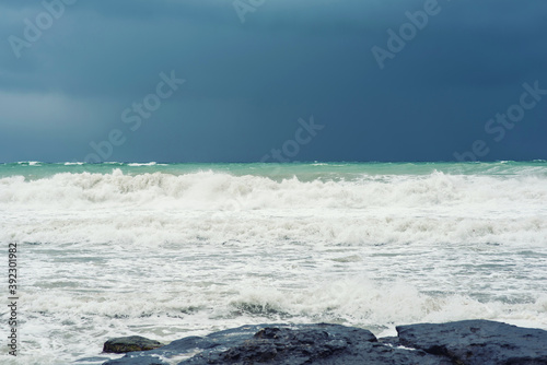Autumn sea landscape. Rough sea with waves during autumn stormy weather. Dark heavy clouds in the sky. Dark and dramatic storm clouds background.