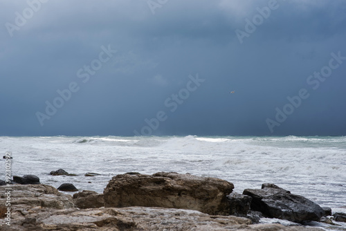 Autumn sea landscape. Rough sea with waves during autumn stormy weather. Dark heavy clouds in the sky. Dark and dramatic storm clouds background.