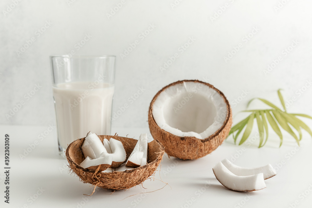 coconut and coconut milk in a glass Cup on a light background. copy space. selective focus coconut and coconut milk in a glass Cup on a light background. copy space. selective focus