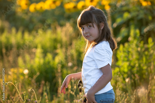 September 2020, Bibbiano, Italy. Sweet little girl poses for a photograph in a sunflower field photo