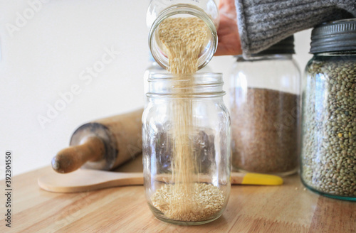 Woman pouring Quinoa into jar photo