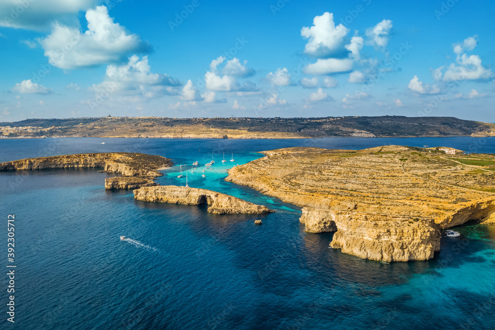 Aerial drone top view of Comino island, Blue lagoon and boats, caves. Malta island