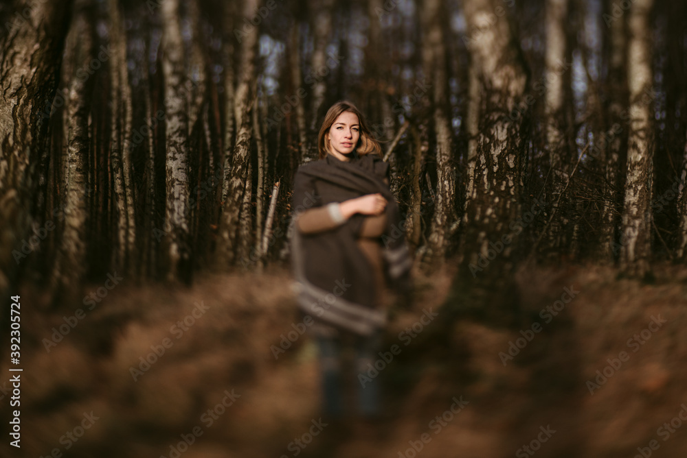 Calm woman standing in leafless forest Calm woman standing in leafless forest