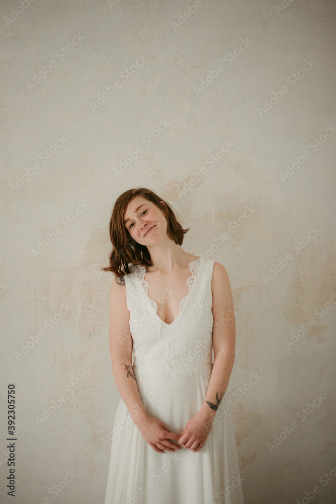 Joyful tattooed bride in wedding dress at home Joyful tattooed bride in wedding dress at home