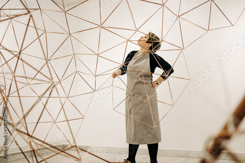 Woman Artist Assembling A Large Metal Sculpture photo