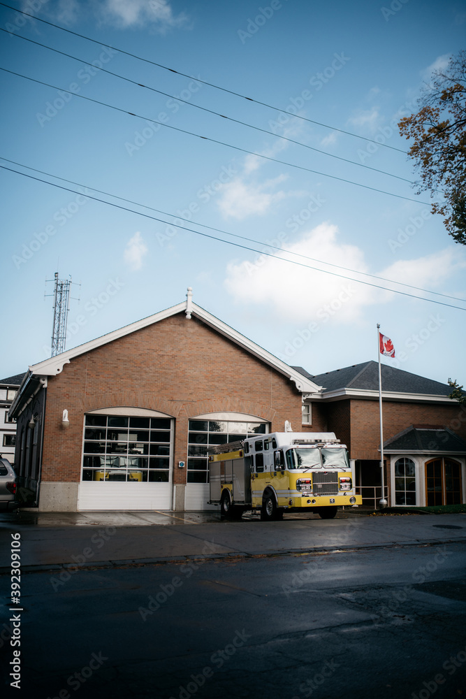 Yellow fire truck in front of fire department building Yellow fire truck in front of fire department building
