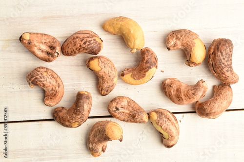 Several roasted cashews, close-up, on a wooden table.