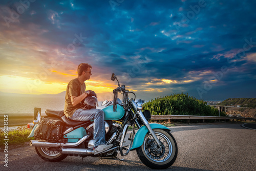 Man on a classic motorcycle on the edge of the road