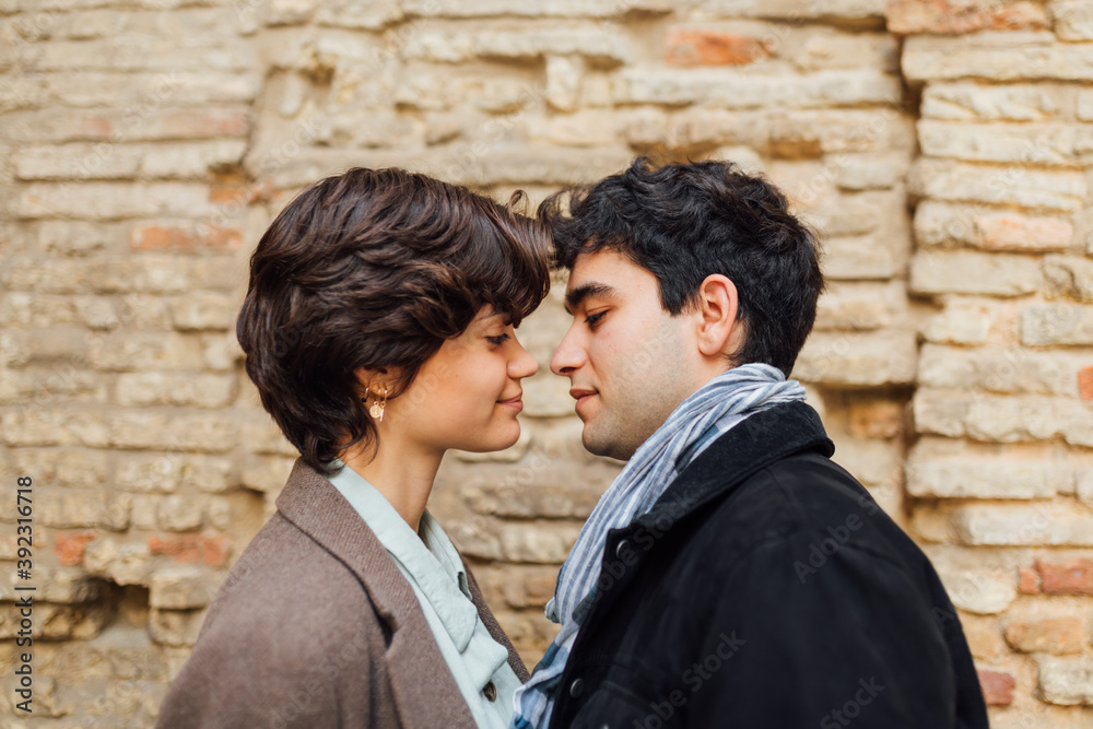 Handsome guy kissing girl with short hair on the cheek Handsome guy kissing girl with short hair on the cheek
