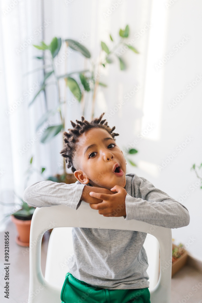Lovely mixed race boy with dreadlooks making faces at home Lovely mixed race boy with dreadlooks making faces at home