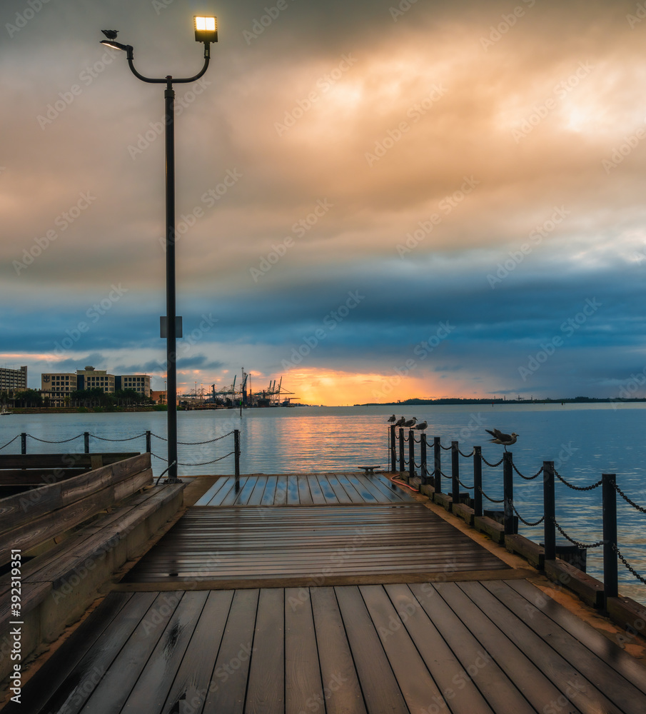 pier at sunset sunrise cloudy day clouds sea pier birds seagulls wooden floor  wet rain 