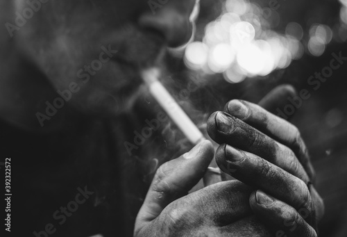 grimy man smokes a cigarette photo