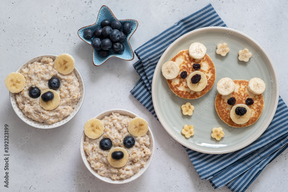 Kids breakfast oatmeal porridge and pancakes with funny bear face Kids breakfast oatmeal porridge and pancakes with funny bear face