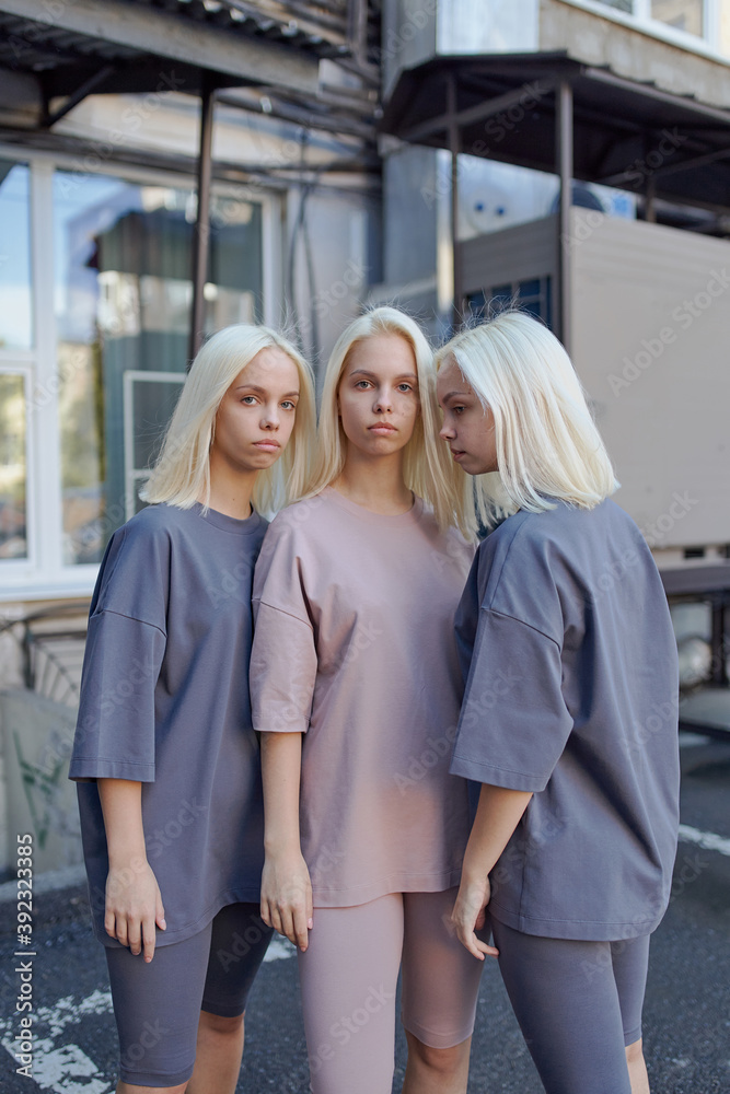 triplet sisters stand on the street in yoga clothes triplet sisters stand on the street in yoga clothes