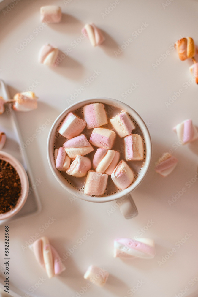 Ceramic cup of hot chocolate or cocoa with marshmallow on white table. Decoration garlands of lights. Flat lay, healthy food concept