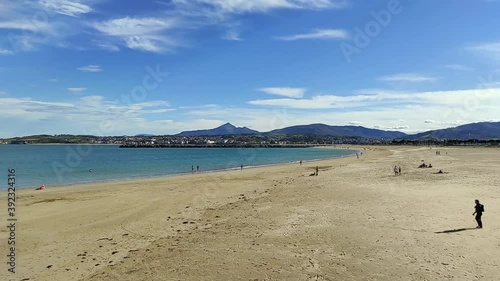 Una persona en la playa de Hondarribia en un día claro con Hendaya al fondo