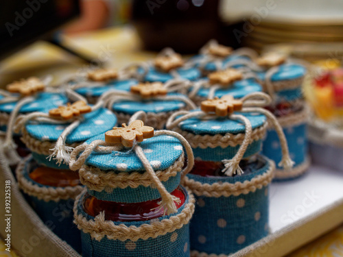 Gifts to guests for a special birthday party. Bonbonniere made with glass jars, fabric and small wooden butterflies.