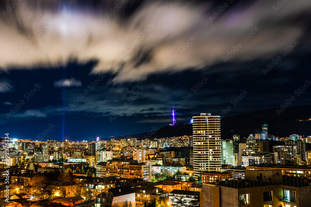 Fototapeta premium Running clouds in night sky over Tbilisi