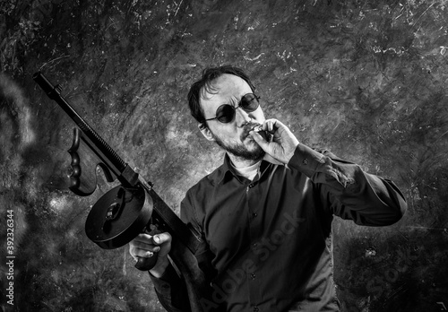 Mature man in sunglasses with tommy gun photo