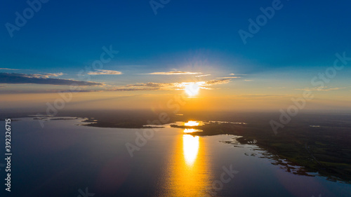 Scenic view from drone over sunset on big water and coastal line.