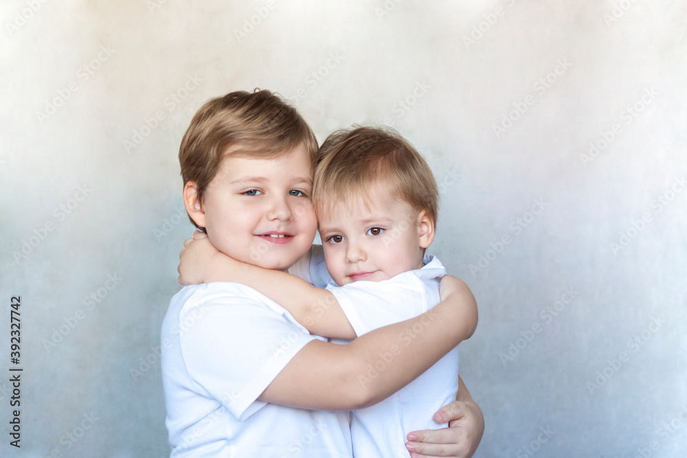 Boys-brothers in an embrace. Happy boys hug each other. Overjoyed, the best friends embrace. Boys-brothers in an embrace. Happy boys hug each other. Overjoyed, the best friends embrace.