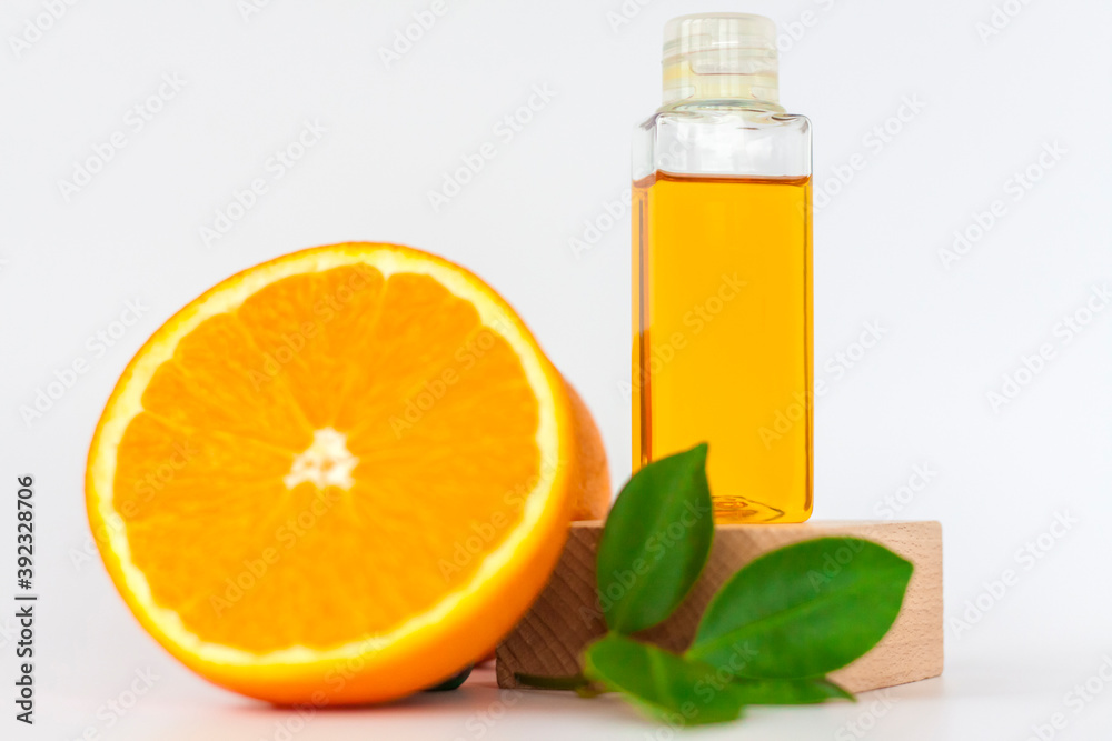 Orange oil for the body. Orange on a wooden pedestal on a white background. Organic SPA cosmetics with herbal ingredients. Orange oil for the body. Orange on a wooden pedestal on a white background. Organic SPA cosmetics with herbal ingredients.