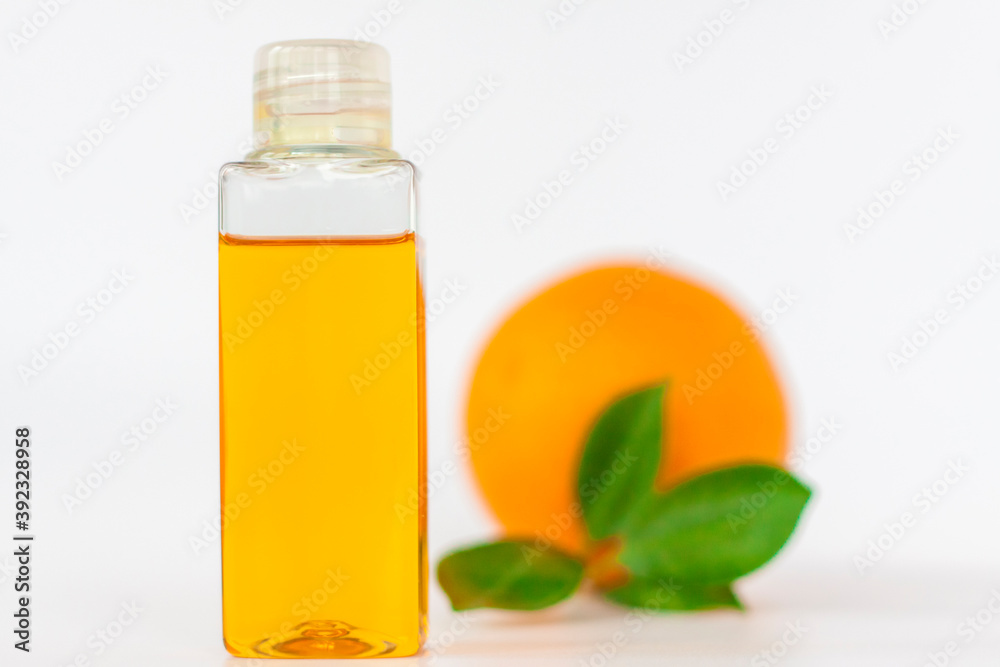 Orange oil for the body. Orange on a white background. Organic SPA cosmetics with herbal ingredients.