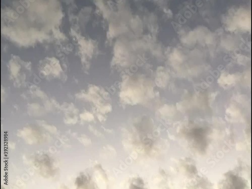 Fluffy clouds at early sunset. Timelapse