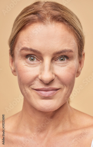 Smiling mature woman posing at camera in studio
