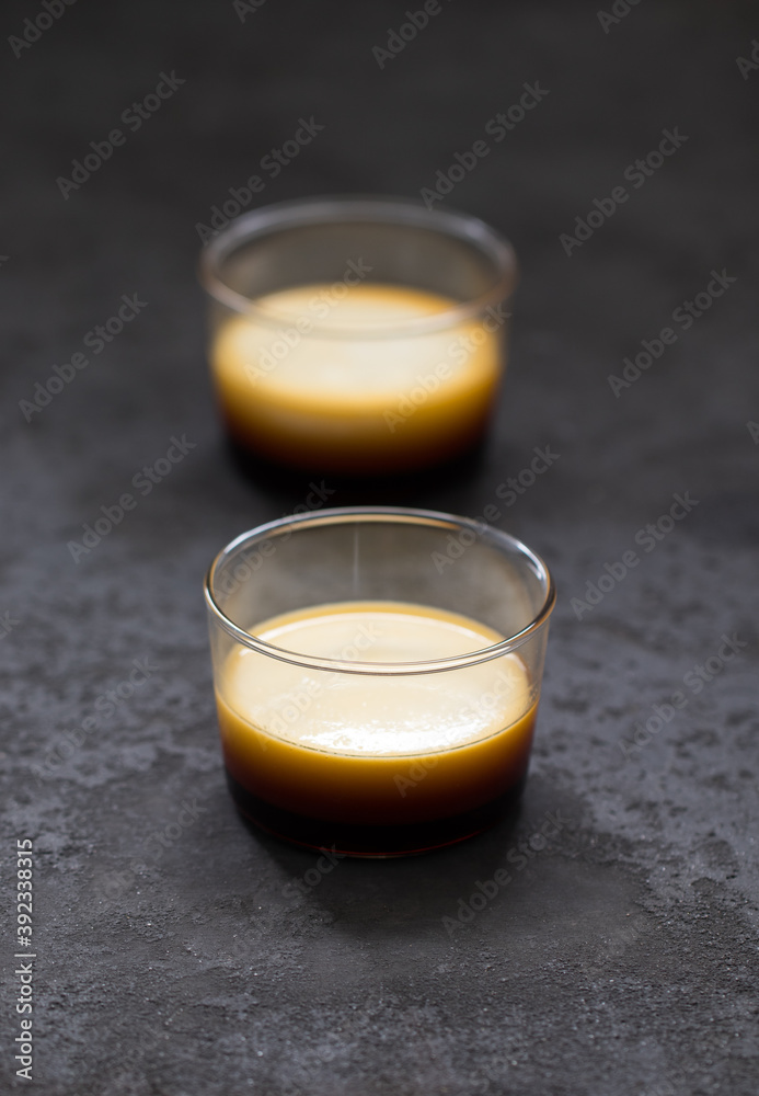 Flan pudding cream caramel in a glass Cup on a dark gray background Flan pudding cream caramel in a glass Cup on a dark gray background