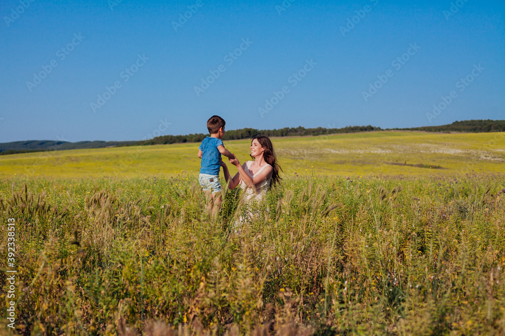 mom and son together in a field with yellow flowers