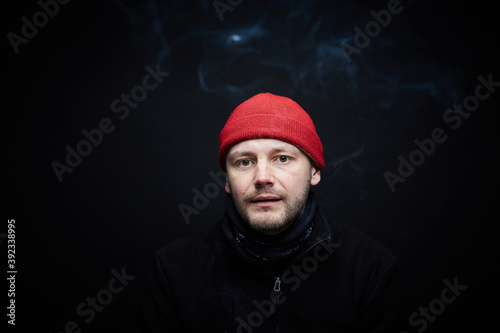 Portrait of a person in red hat, black background