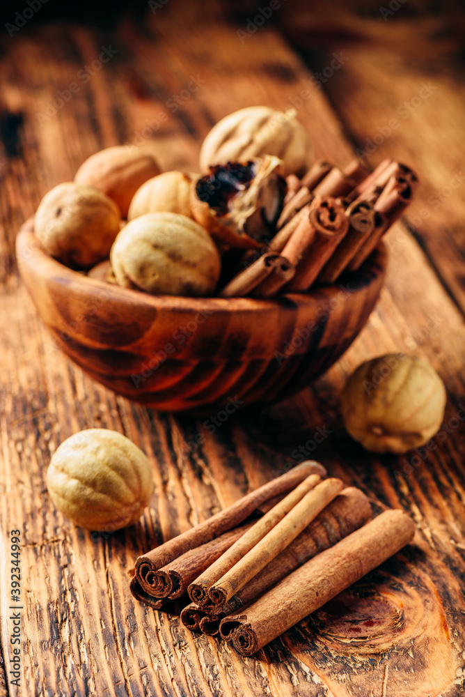 Cinnamon sticks and dried limes in wooden bowl Cinnamon sticks and dried limes in wooden bowl
